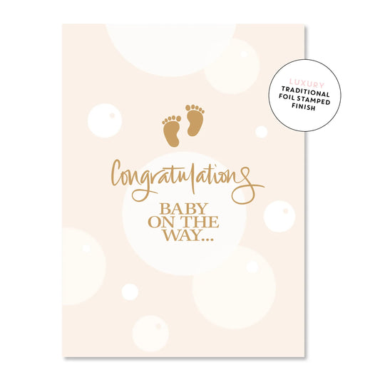Baby greeting card with a footprint and several circle designs with the words "Congratulations, Baby On The Way!"